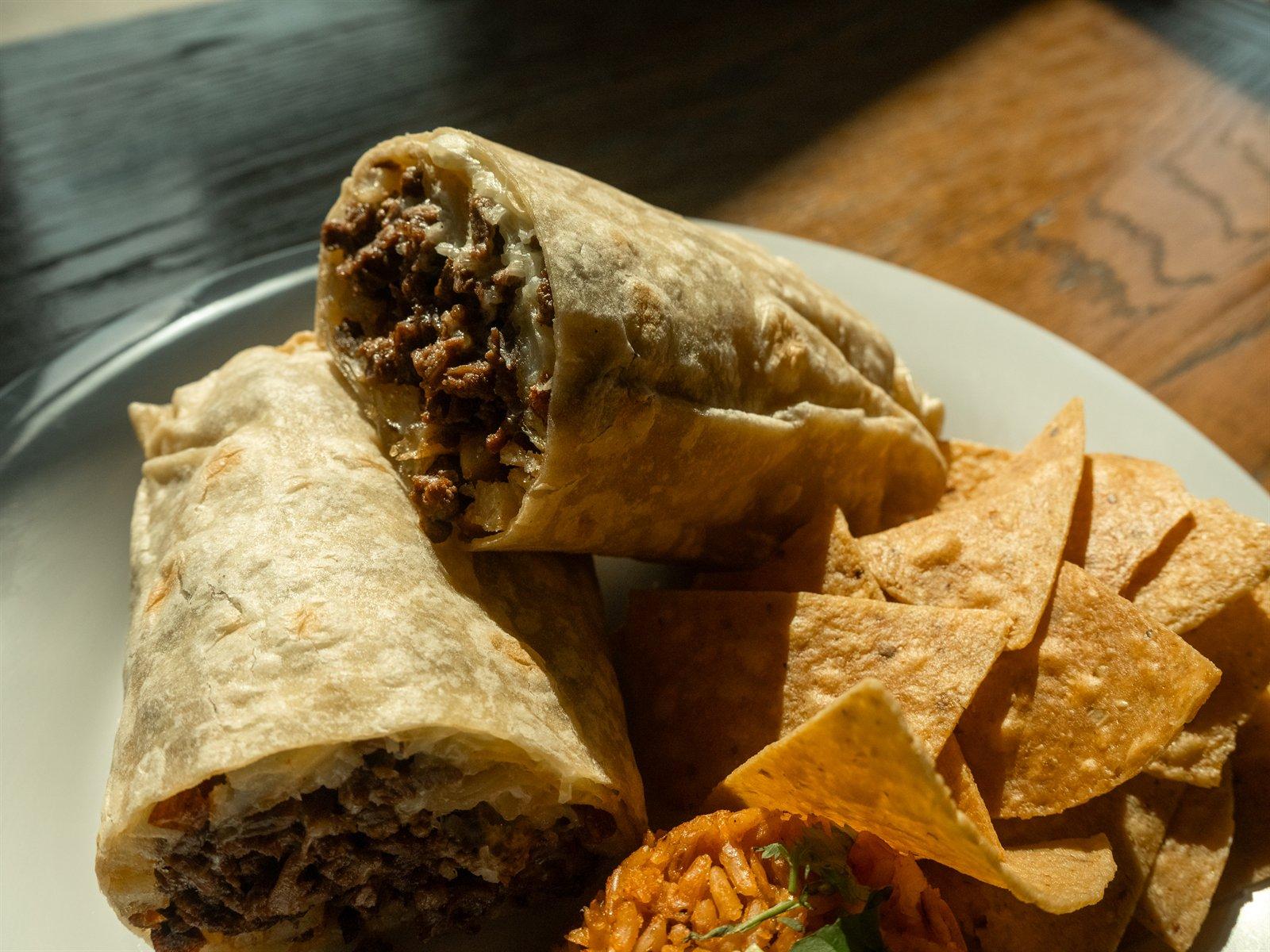 Classic burrito halves with rice and chips