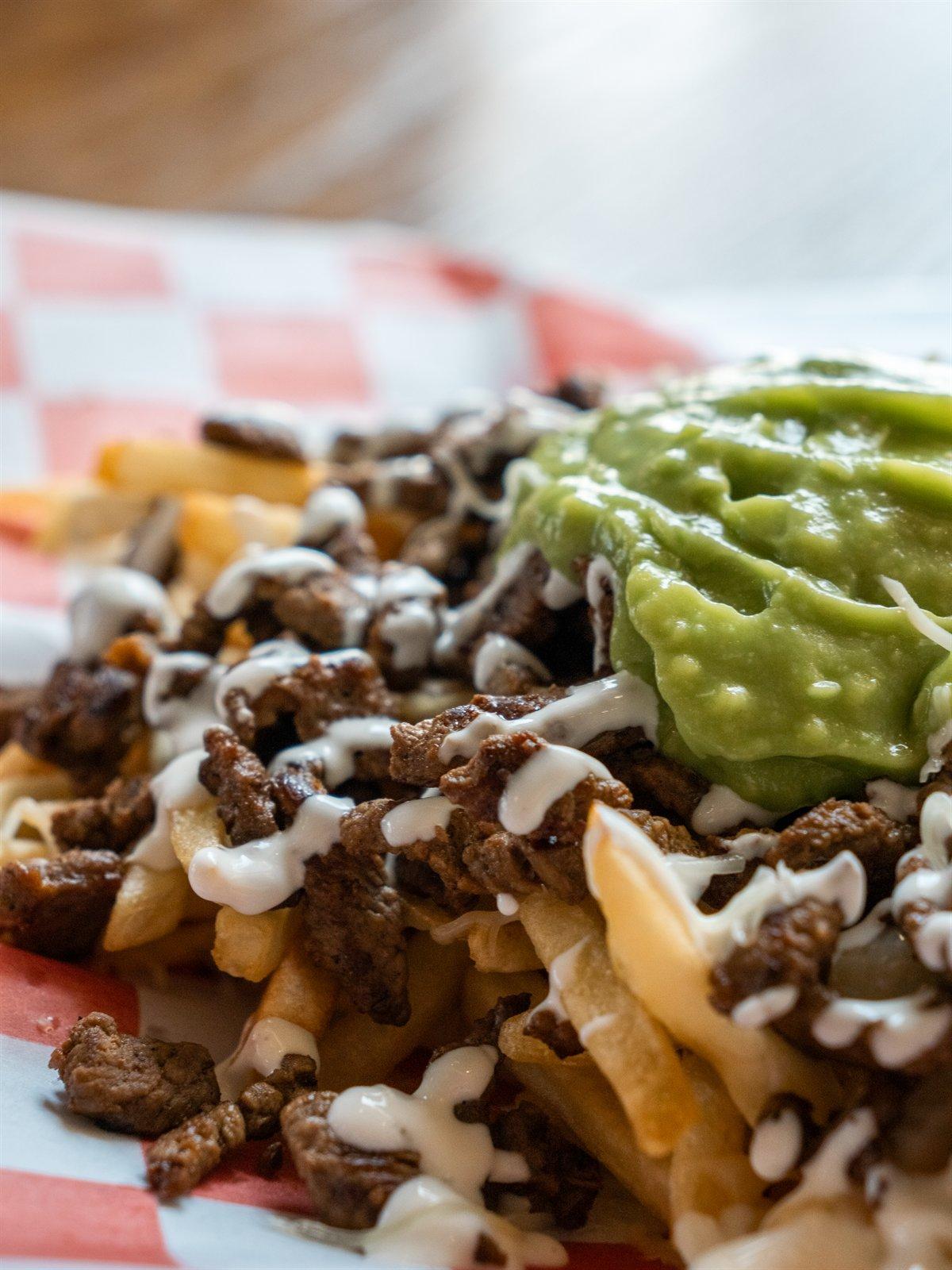 Loaded asada fries with guacamole and crema