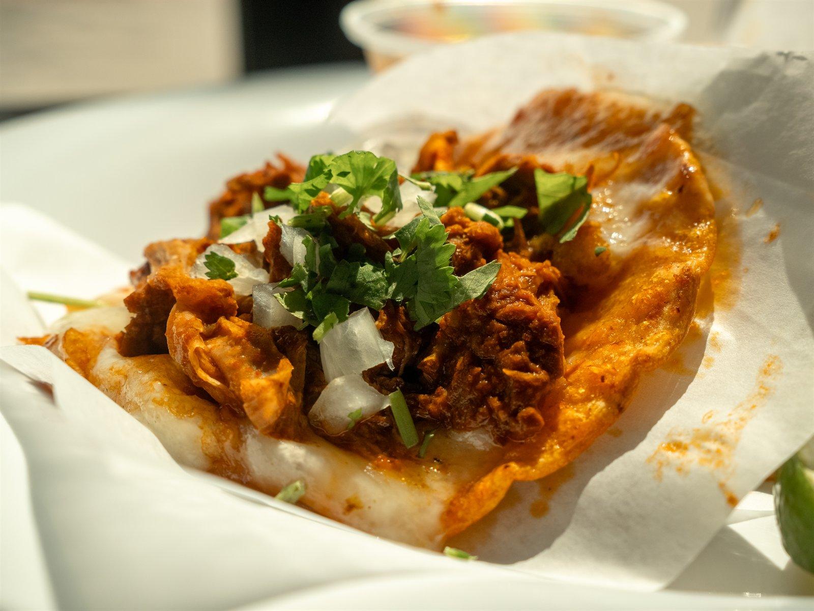 Red queso taco with consomé